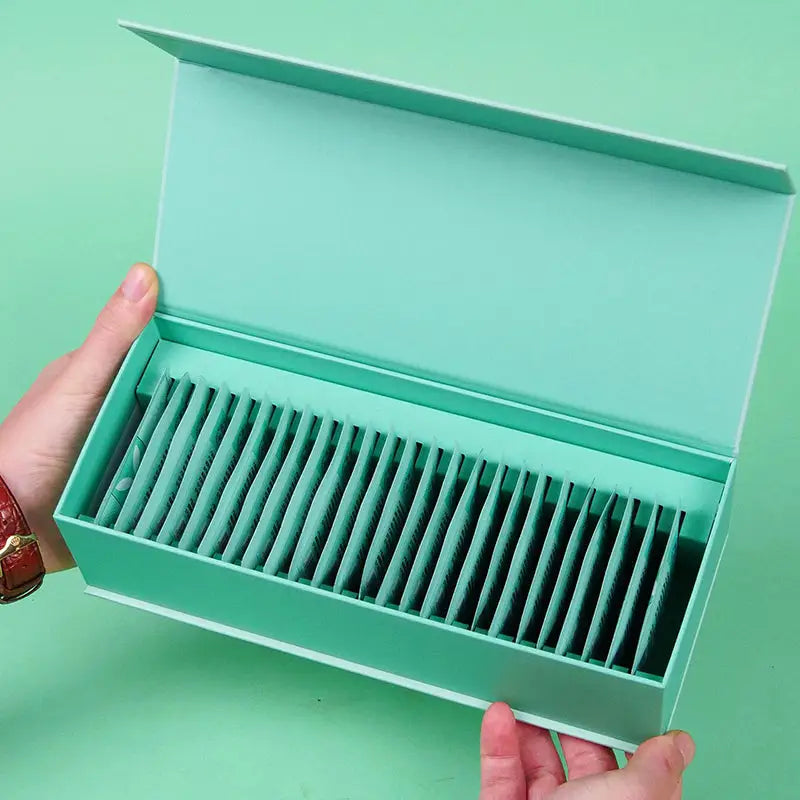 Open mint-colored box filled with Jasmine White Tea Leaves, perfect for tea sets or mugs