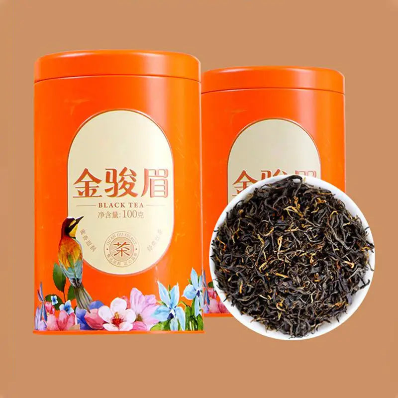 Orange tea tins with loose black tea for Jin Jun Mei Red Tea Leave in elegant teapots and mugs