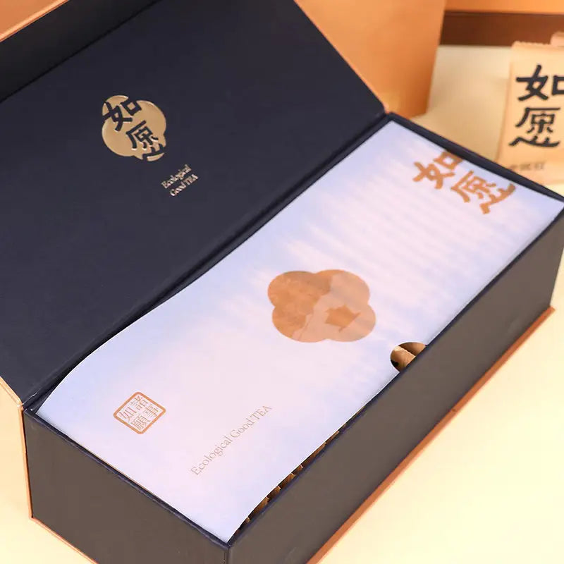 Open gift box featuring Jin Jun Mei Red Tea Leaves with teapots and tea sets setup