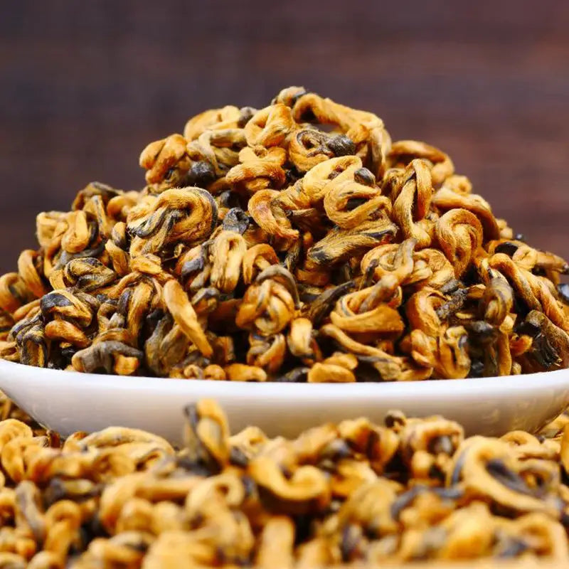 Pile of golden curl tea leaves ideal for teapots, tea sets, and mugs for Jin Luo Red Tea Leave