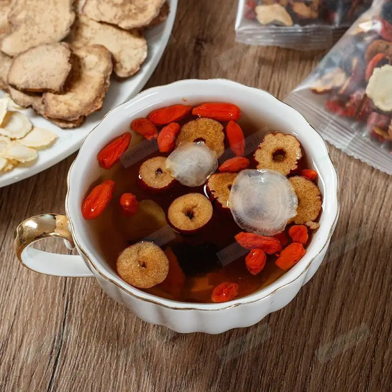 Cup of herbal tea with floating ingredients for kidney protection and reducing fatigue