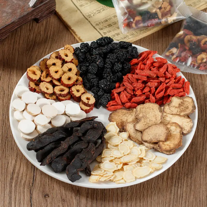 Assorted dried medicinal ingredients on plate for kidney protection and reducing fatigue