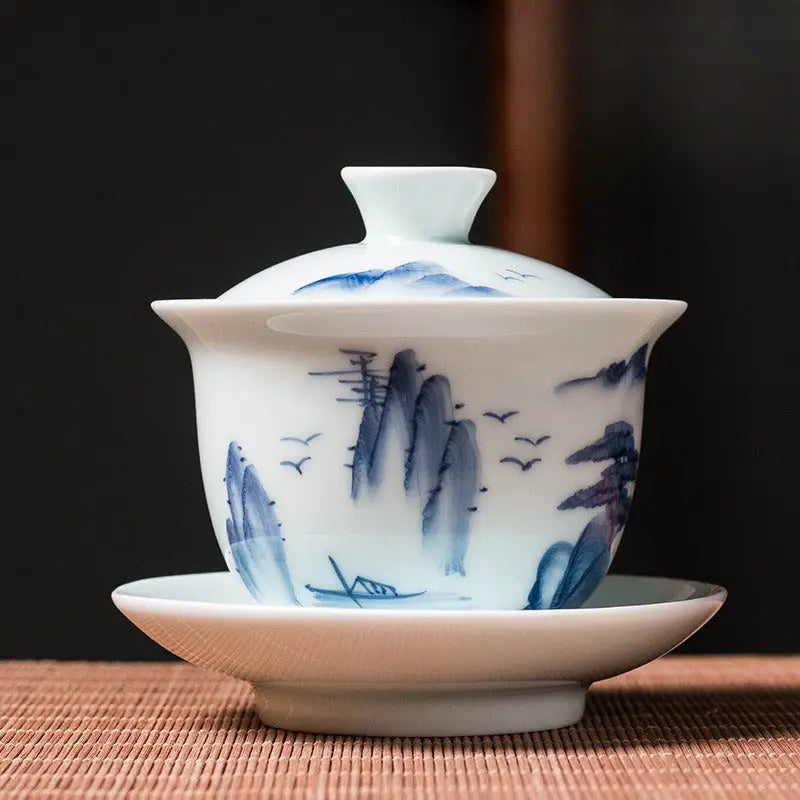 White porcelain tea set with blue mountain landscape design showcasing Jingdezhen enamel art