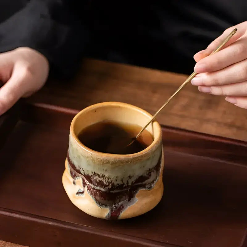 Lava Whisper handcrafted ceramic coffee cup with a stirring stick for tea and coffee enjoyment