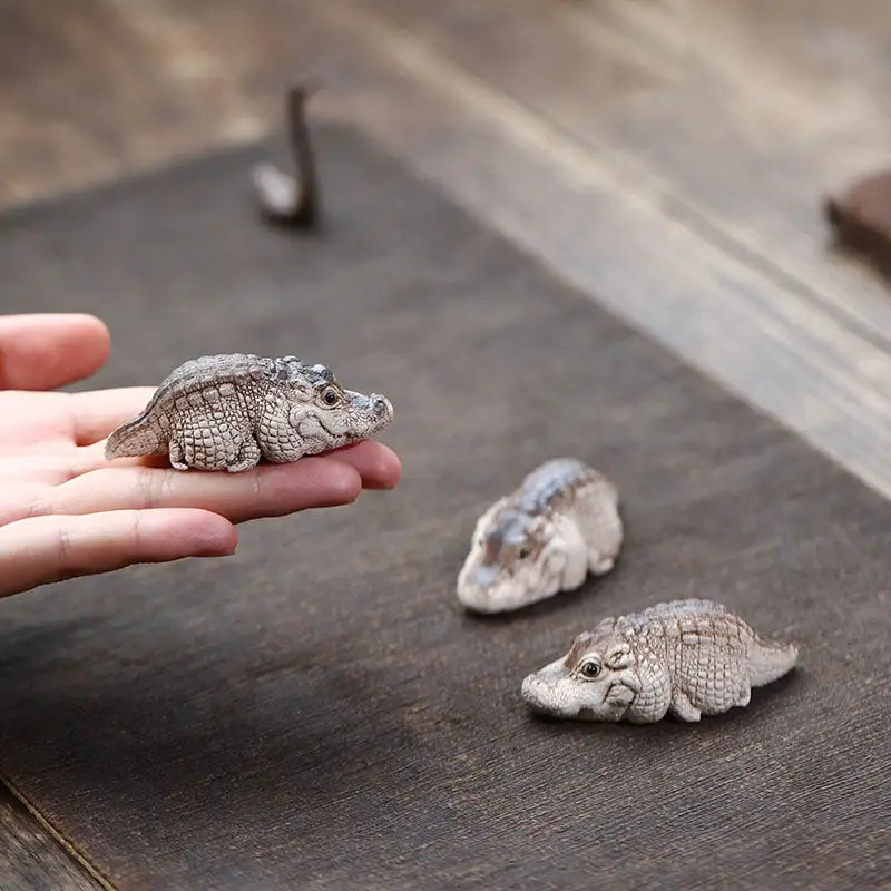 Miniature crocodile figurines as a unique crocodile tea pet made from Yixing Zisha clay for feng shui