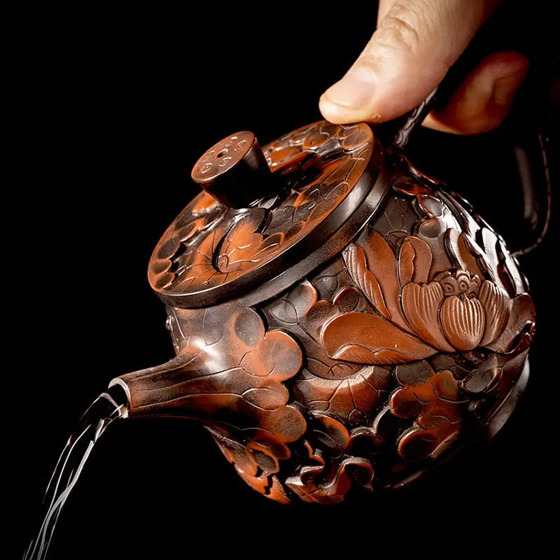 Ornate brown Lotus Flower II teapot pouring water, made from purple clay Jianshui Zitao