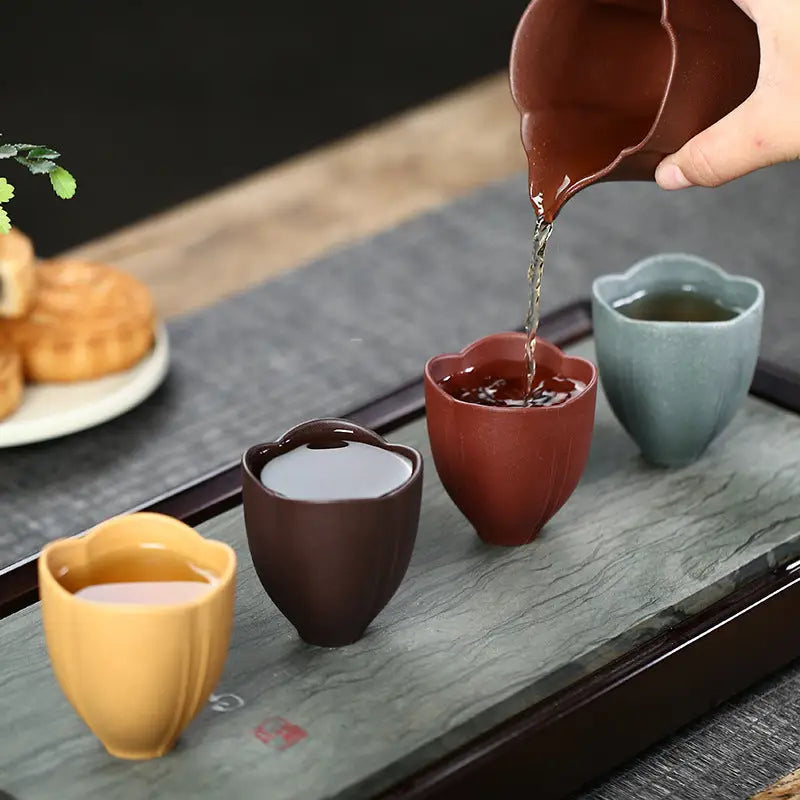 Colorful tea cups being filled with Lotus Heart Zisha authentic Yixing heart Zisha cup