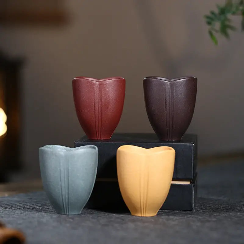 Four tulip-shaped ceramic cups from Lotus Heart showcasing authentic Yixing heart Zisha craftsmanship