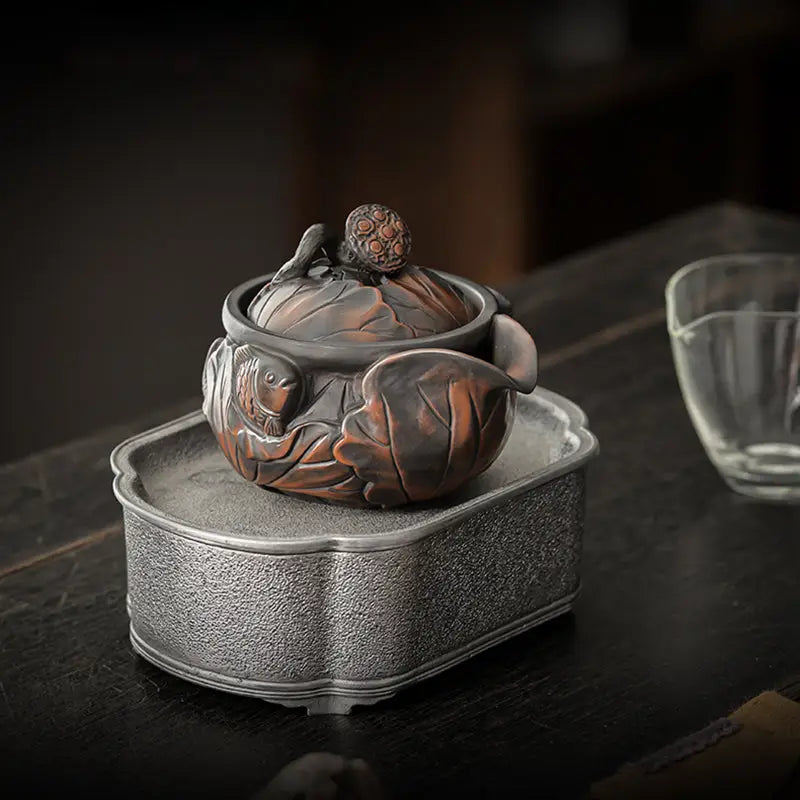 Ornate dark-toned Jianshui Zitao teapot with leaf and lotus pod details for tea enthusiasts