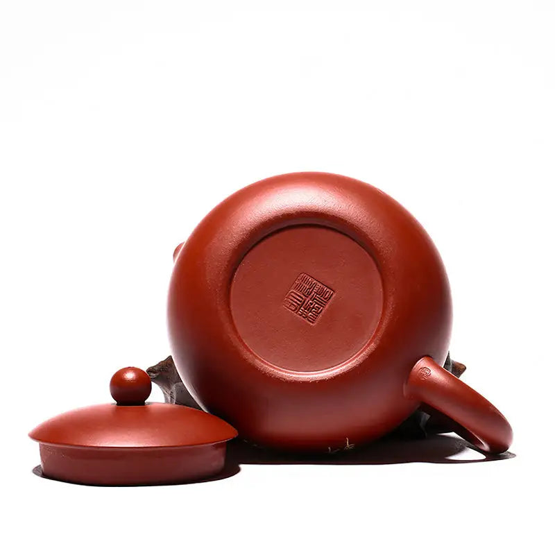 Red-brown Yixing Zisha ceramic teapot with lid, featuring a hand-painted lotus design