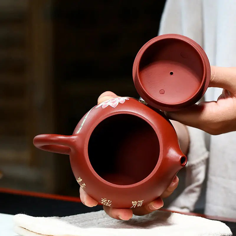 Reddish-brown Yixing Zisha ceramic teapot with open lid, hand-painted lotus design
