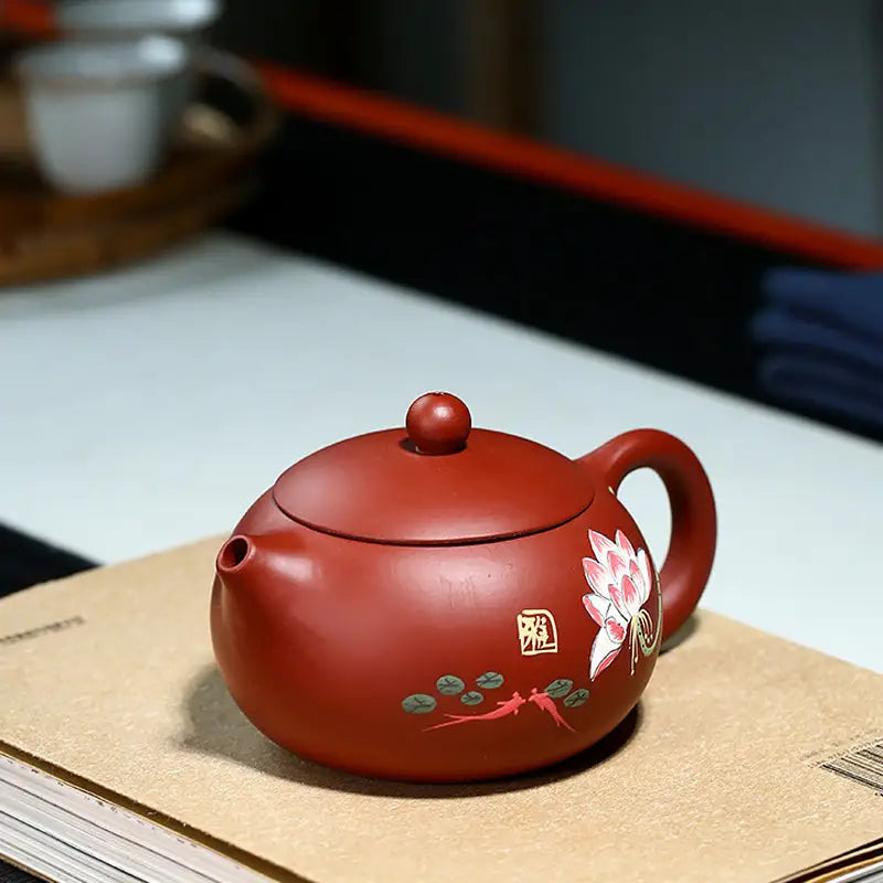 Reddish-brown Yixing Zisha teapot with hand-painted lotus floral design in purple clay