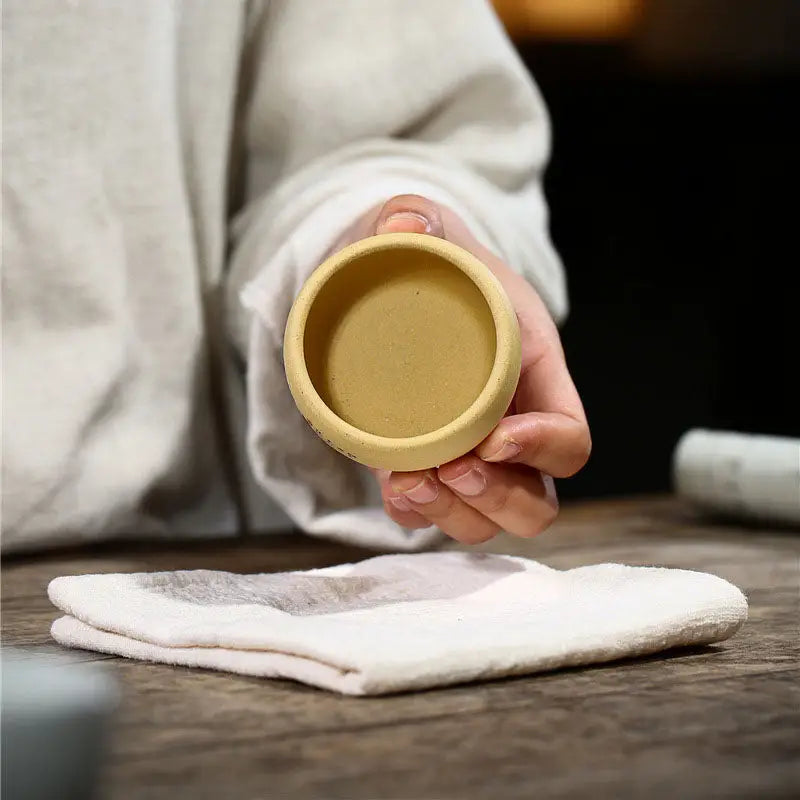 Round tan-colored ceramic cup from Lotus Serenity, hand-painted yixing zisha teacup