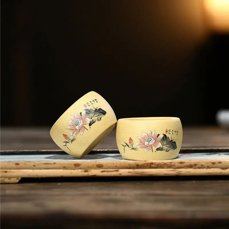 Two yellow hand-painted Yixing Zisha teacups with lotus flower designs for Lotus Serenity