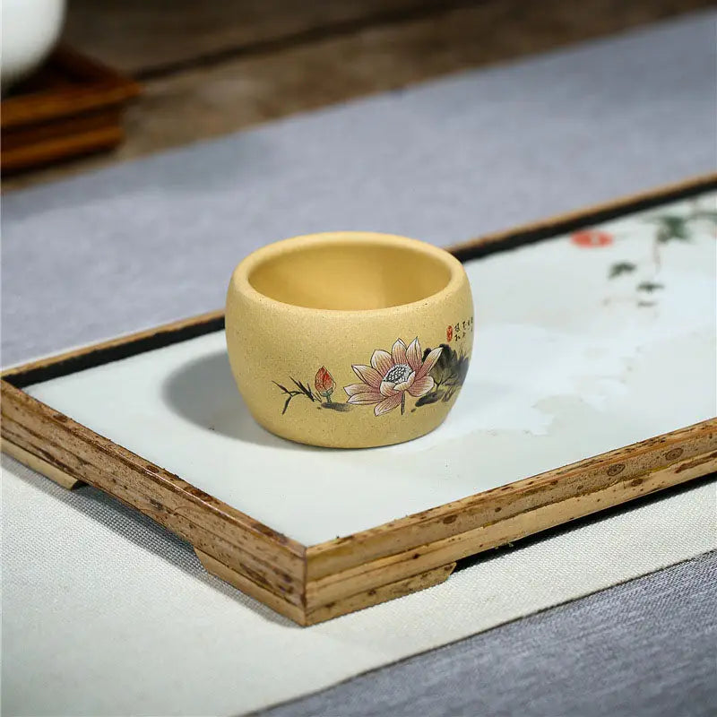 Round yellow Lotus Serenity teacup with hand-painted lotus flower design in poetic calligraphy