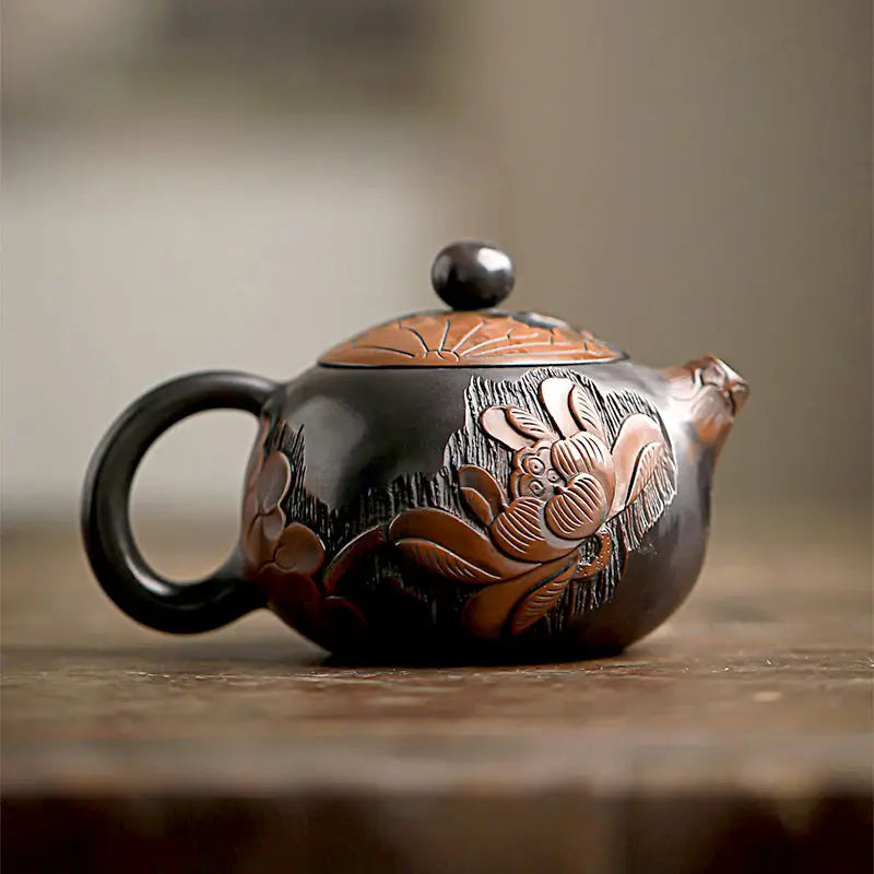 Dark ceramic Lotus teapot with hand-carved lotus and rabbit floral design in Zisha clay