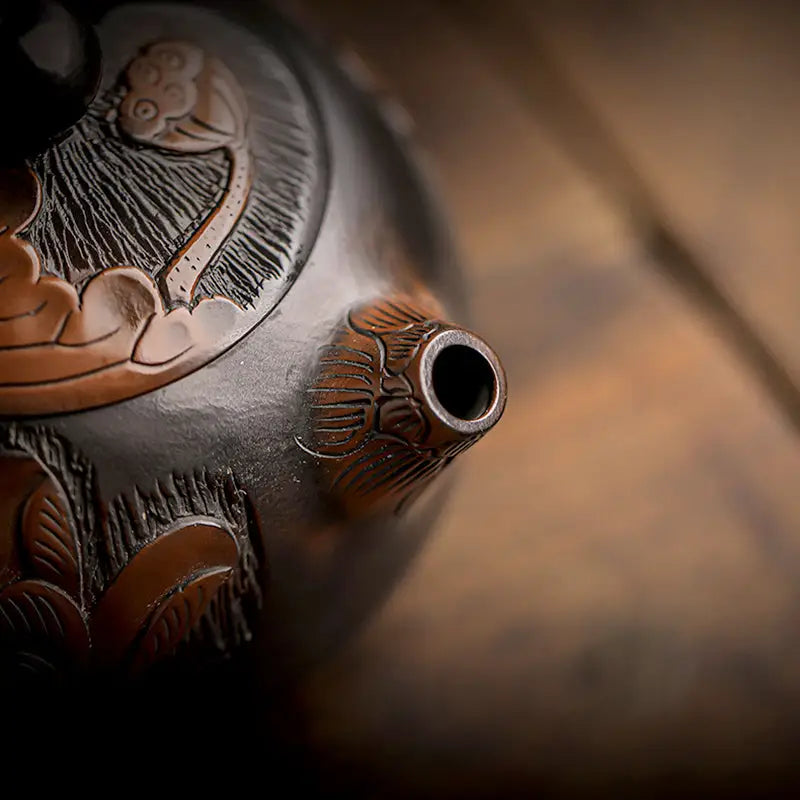 Ornate dark-toned teapot spout from Lotus handcrafted with zisha clay in a hand-carved lotus design