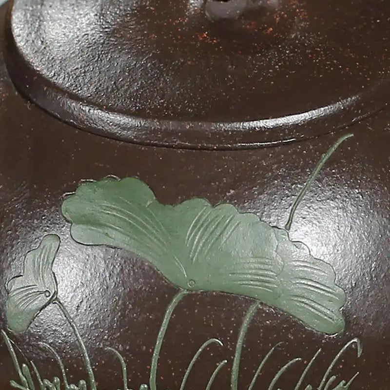 Brown teapot with green hand-carved lotus design made from Yixing Zisha clay for Lotus Whisper