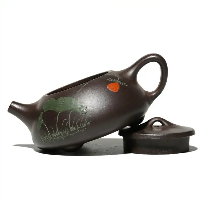 Brown Yixing Zisha teapot with hand-carved lotus design showcasing Zisha clay artistry