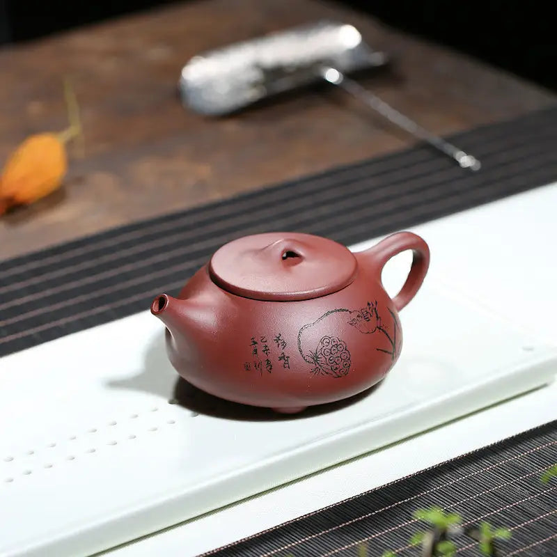 Maroon round ceramic Lotus Whisper Yixing teapot with lotus pod design