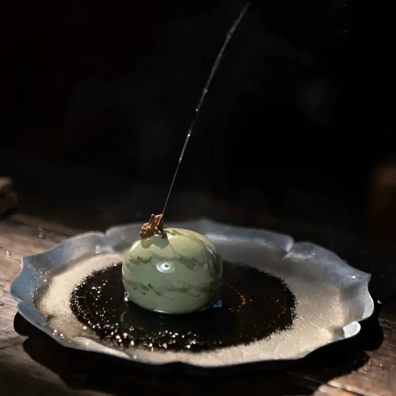 Green marbled sphere with water stream showcasing Lucky Melon Hopper spouting frog teapet