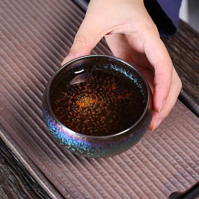 Iridescent glaze tea cup with liquid from the Magic Jian Zhan Gongfu Tea Pot collection
