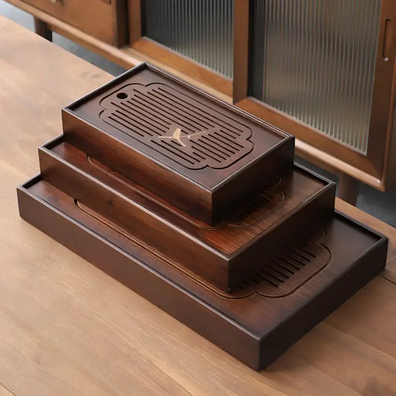 Stacked dark wooden tea trays from Magpie Song Bamboo Tea Tray collection