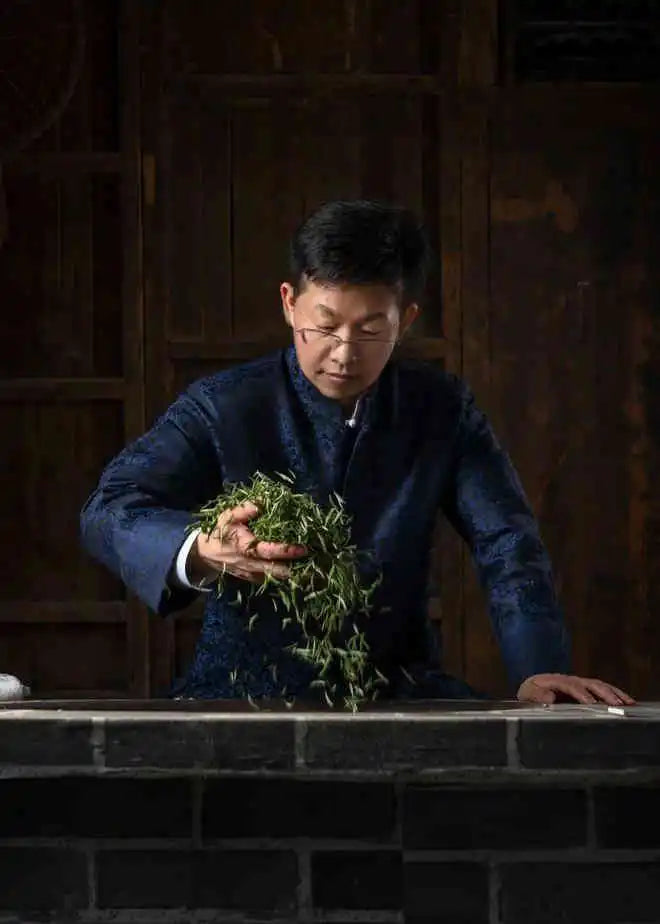 Man holding green tea leaves.