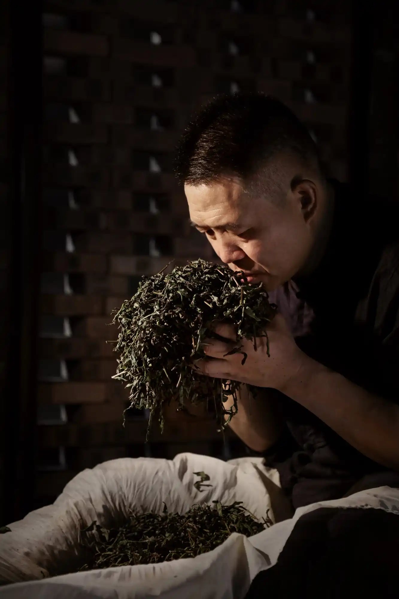 Man smelling tea leaves.