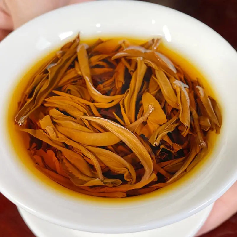 Golden Mao Feng Black Tea Leaves in a white mug, perfect for tea sets and teapots