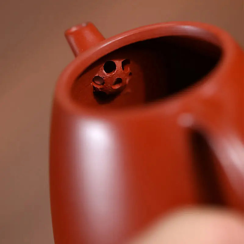 Reddish-brown yixing teapot with perforated spout showcasing Modern Simplicity design