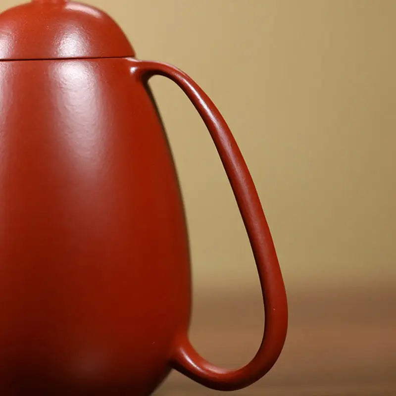 Reddish-brown Yixing Teapot with curved handle from Modern Simplicity collection in red clay