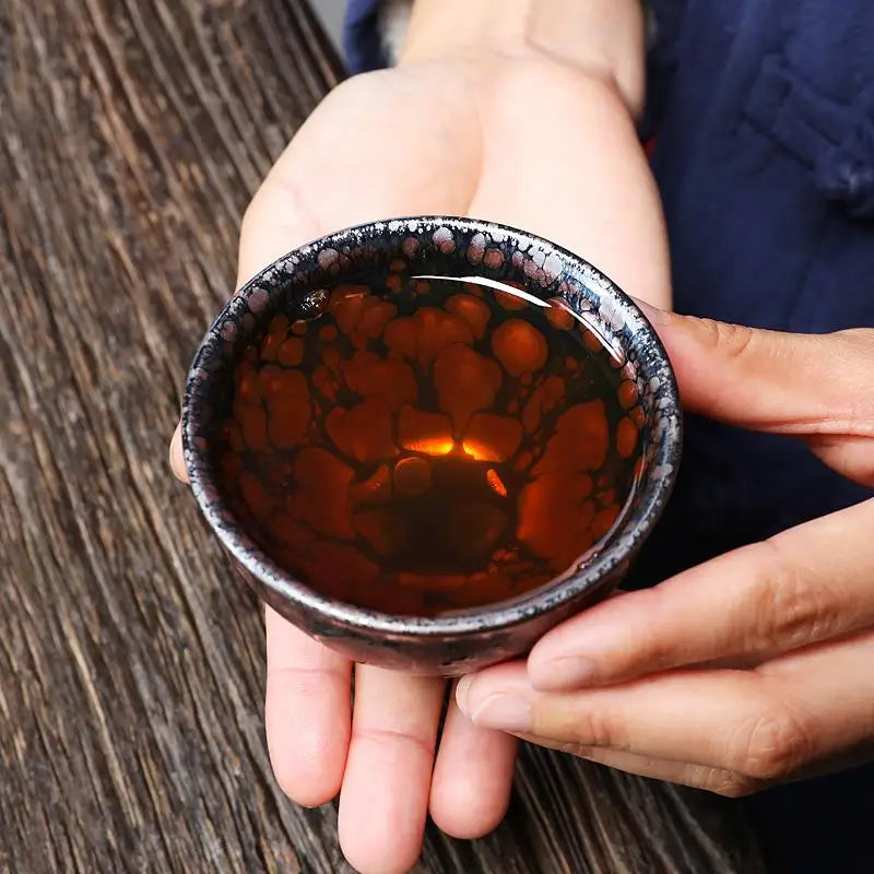 Tea-filled ceramic cup from Molten Jian Zhan tenmoku ceramics for gongfu tea brewing