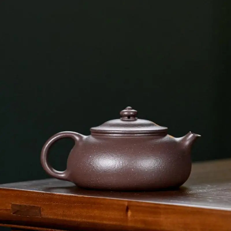 Brown ceramic teapot for Moon Drop tea rituals, ideal for yixing purple tea brewing