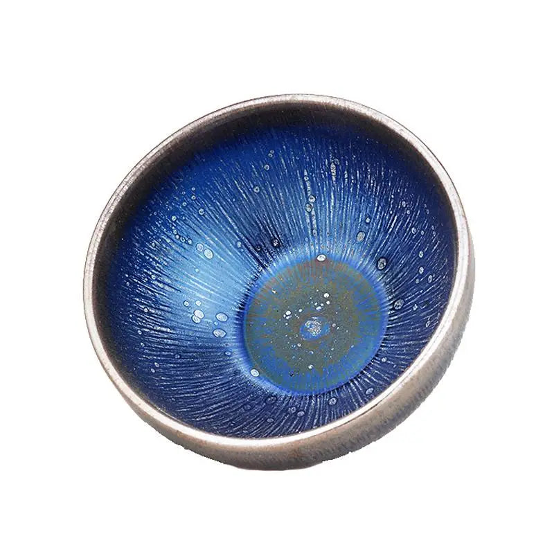 Blue ceramic bowl with silver rim showcasing Night Sky tenmoku glaze Zhan Tea design