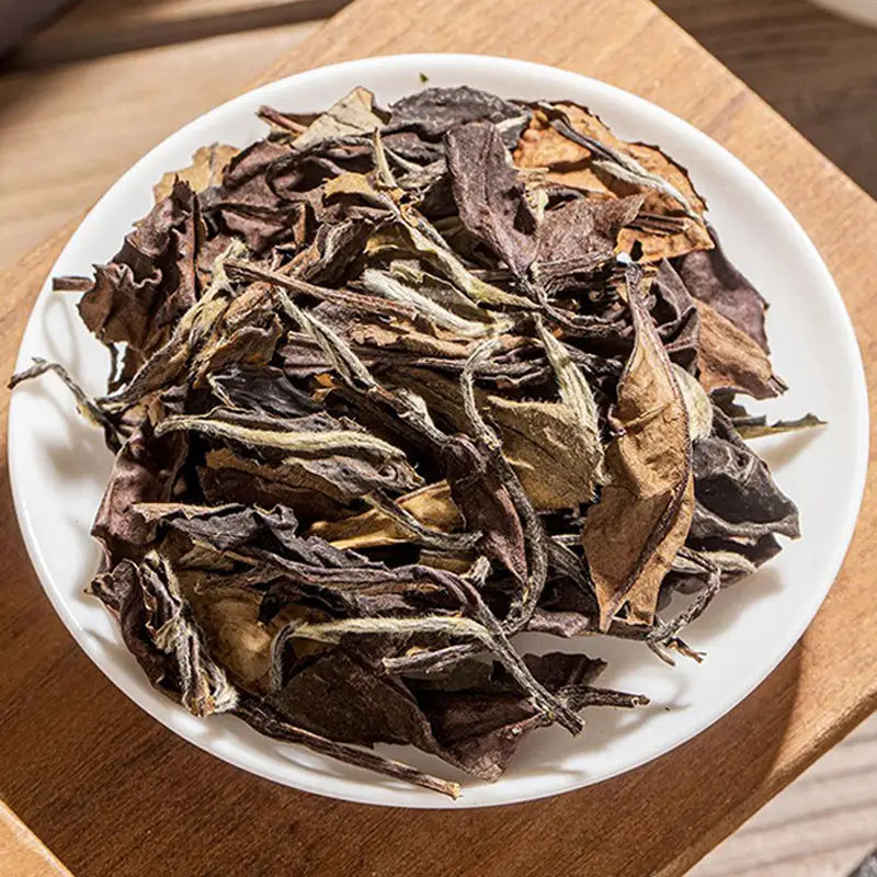Loose-leaf white tea displayed with teapots and tea sets for a relaxing tea experience