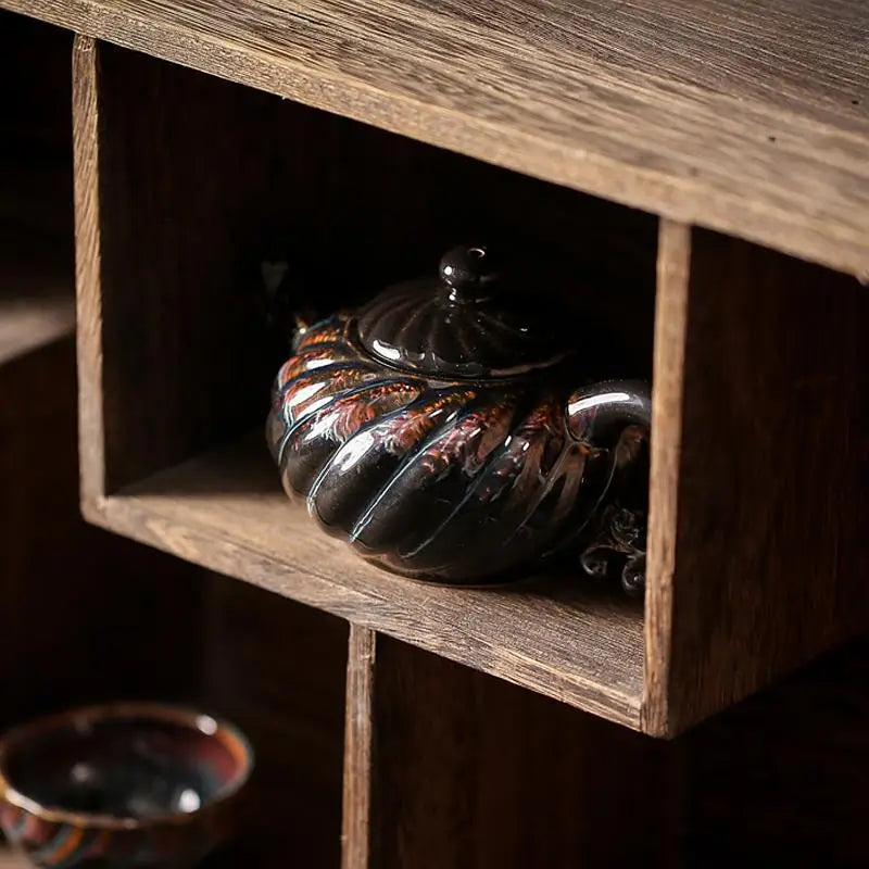 Black ceramic Palm Teapot with red accents, ideal for gongfu tea brewing in Jianyang Tenmoku style with tenmoku glaze