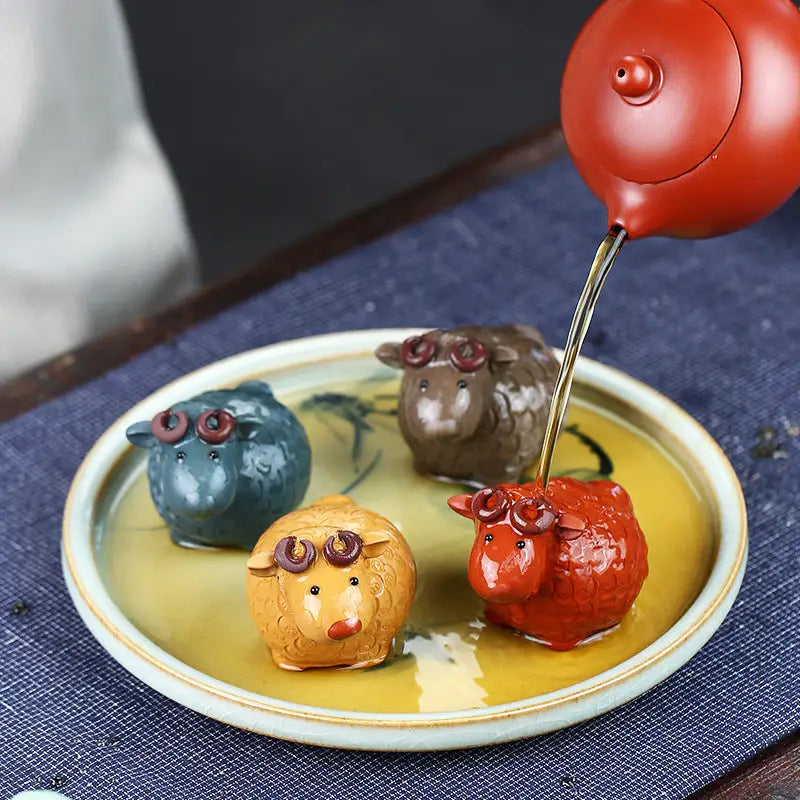 Colorful sheep tea pets on a tray made of Zisha clay, perfect for feng shui in your tea pets guide
