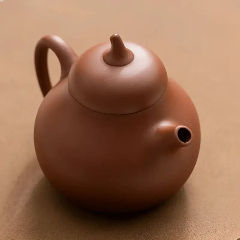 Round brown ceramic teapot from Pearlight Yixing Zisha Tea Set made of zisha clay
