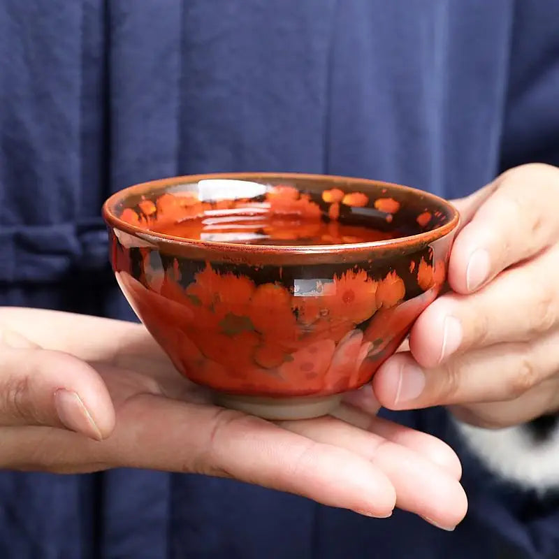 Red and black ceramic teacup in phoenix jian zhan volcanic glaze teacup style