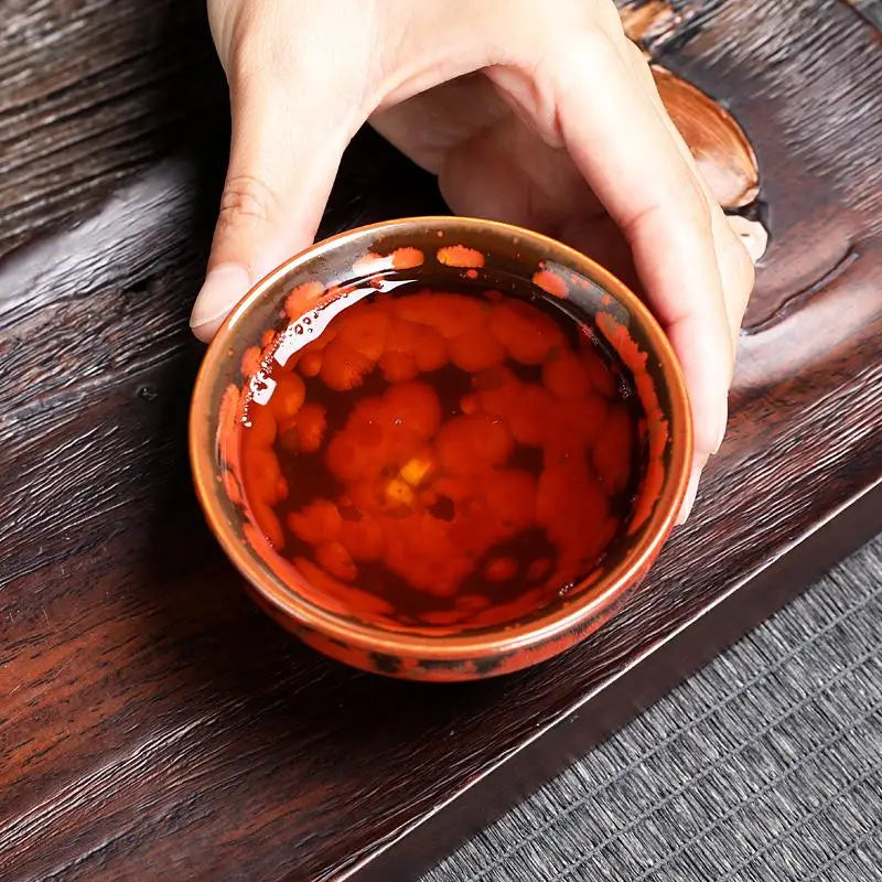 Reddish-brown tea in a volcanic glaze teacup from the Phoenix Jian Zhan collection