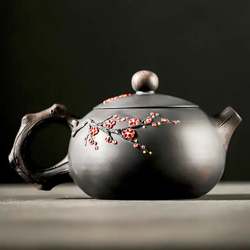 Dark Yixing Zisha teapot with floral Plum Blossom design for elegant tea brewing