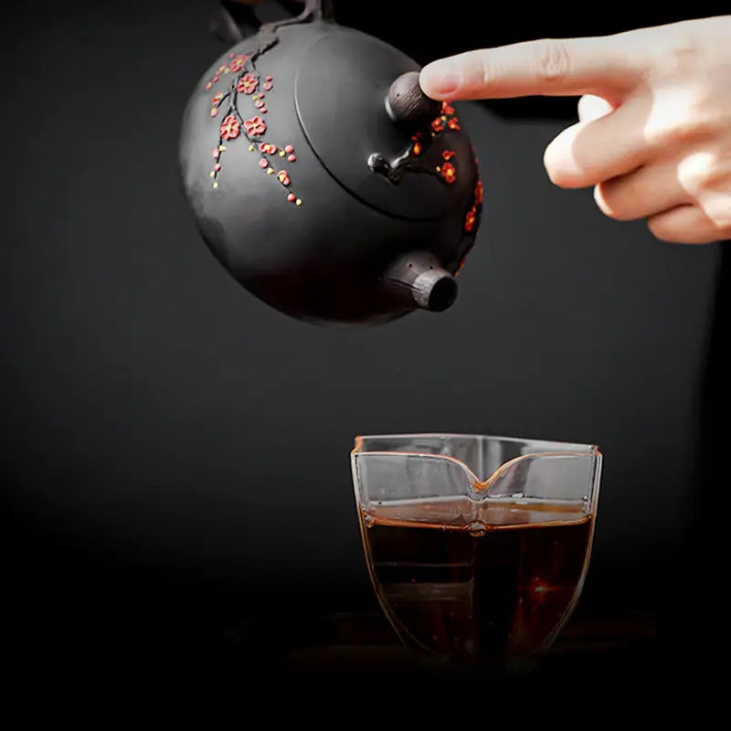 Black Yixing Zisha Plum Blossom teapot pouring tea for authentic teapots experience