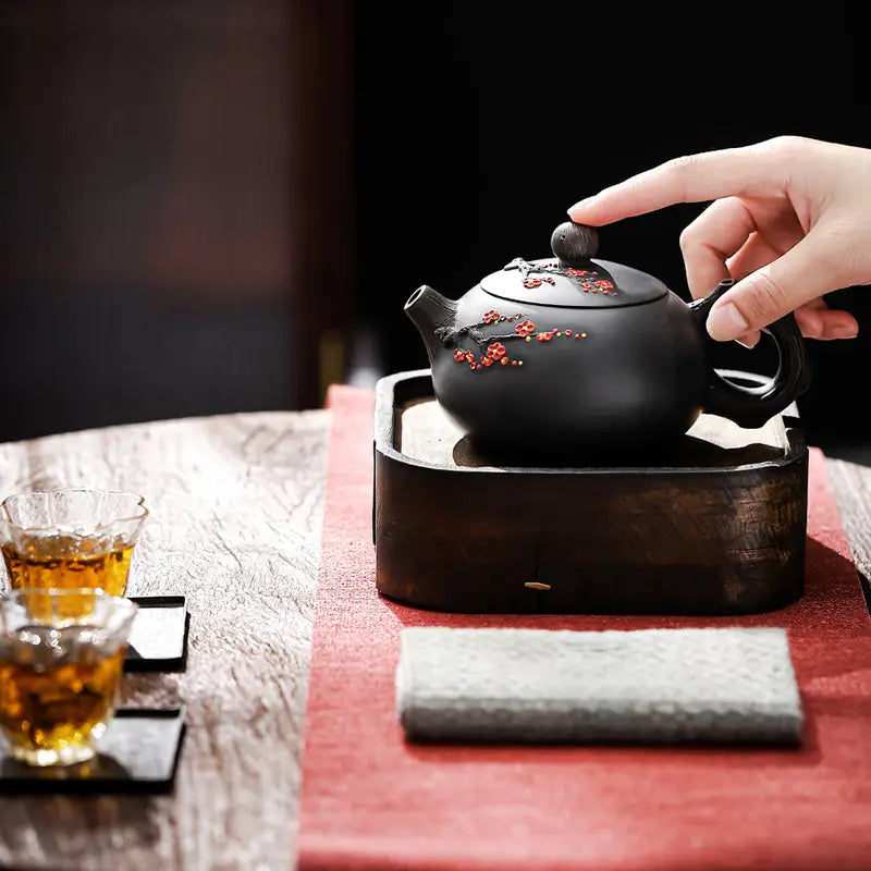 Black Yixing Zisha Plum Blossom teapot with red floral accents for authentic teapots