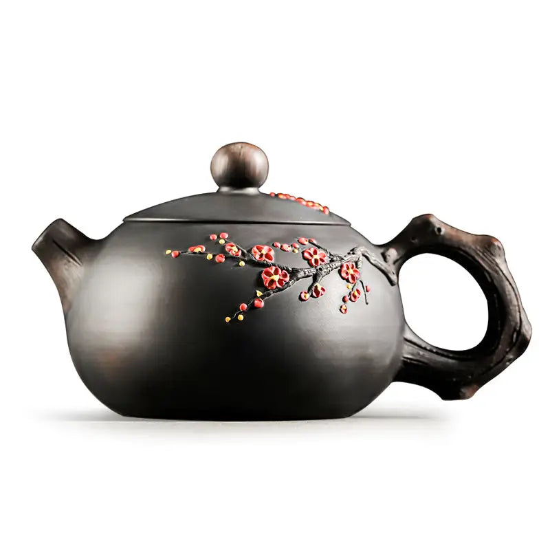 Dark ceramic Yixing Zisha teapot with Plum Blossom floral design for elegant tea brewing