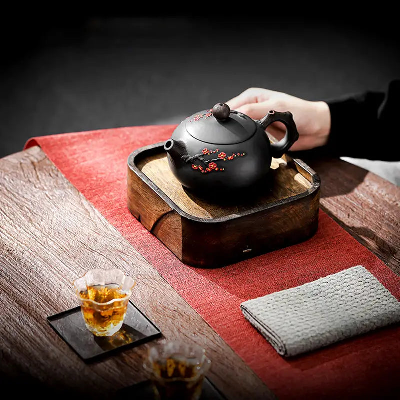 Yixing Zisha Plum Blossom teapot with a black body and red floral design