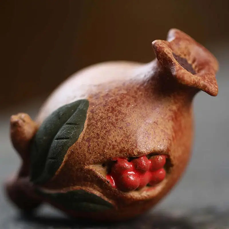 Ceramic Pomegranate Blessing tea pet with exposed red seeds, ideal for feng shui decor