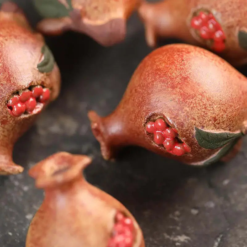 Ceramic pomegranates with visible seeds from Pomegranate Blessing tea pet, ideal for feng shui