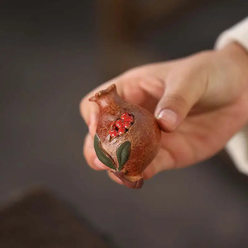 Hand-held ceramic pomegranate tea pet from Pomegranate Blessing for feng shui and tea pets guide