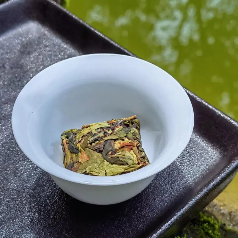 Premium Jasmine Magnolia Dancong compressed Zhangping Shuixian tea brick in a white cup